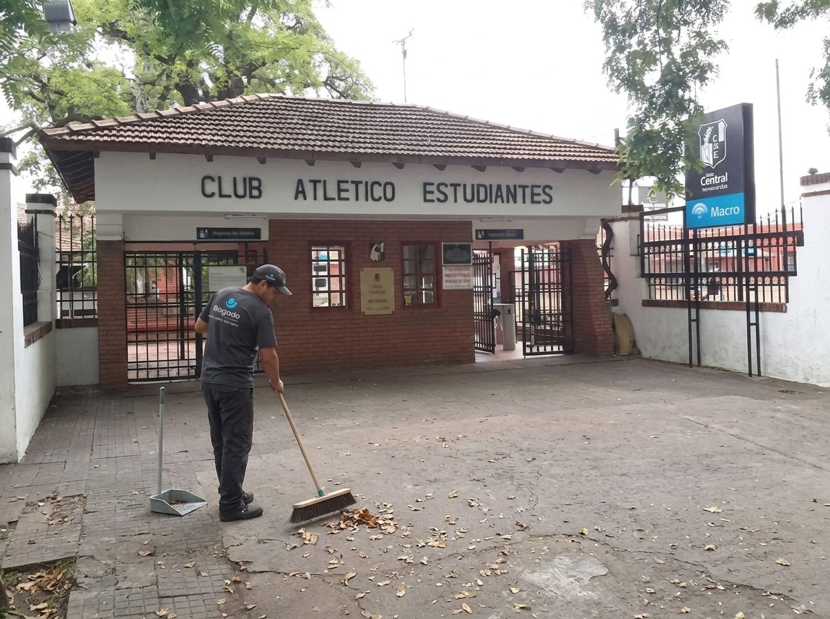 Empleado de Bogado barriendo hojas en la entrada del Club Atlético Estudiantes de Paraná.